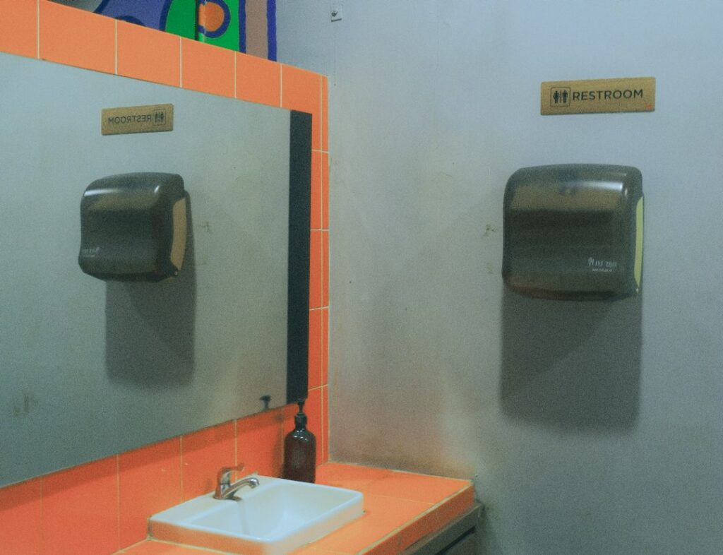 Baño de restaurante con toallas de papel para secado de manos